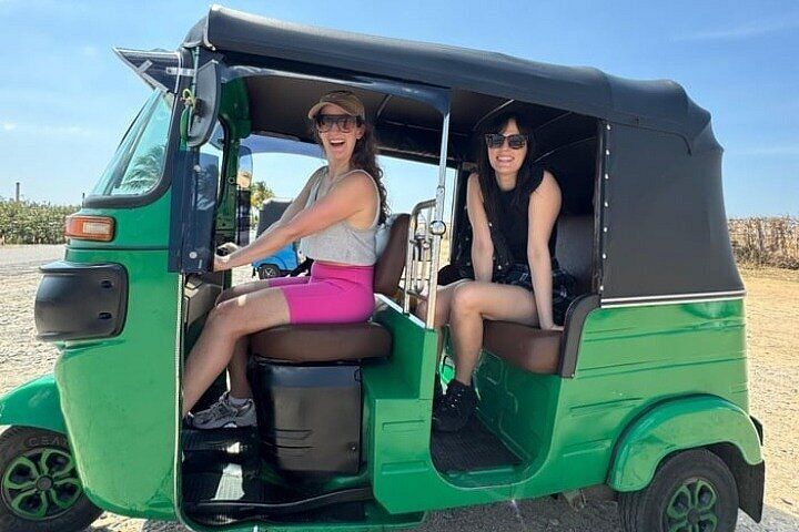 Two guests in a green tuk tuk