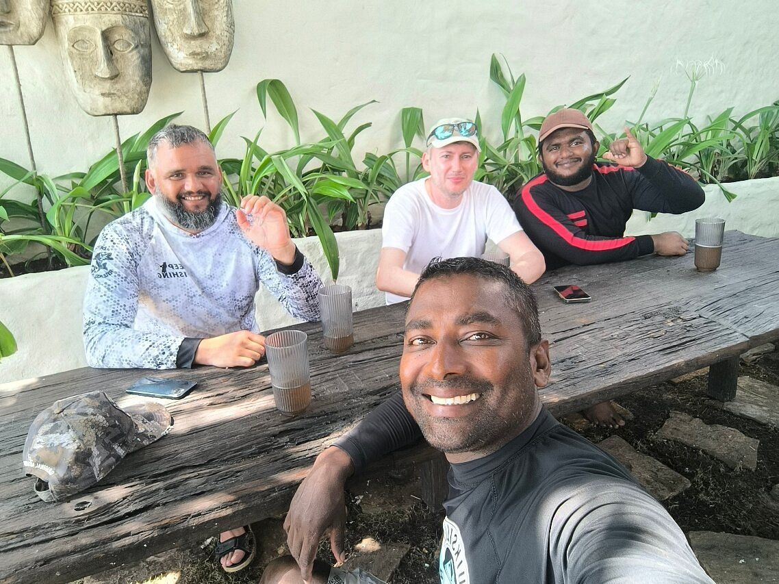 Nipuna and three guests at a wooden table